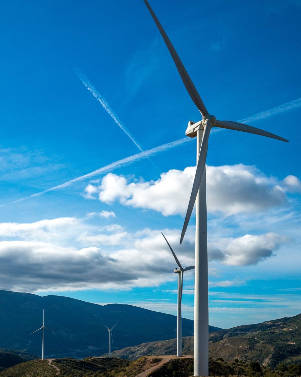 vertical-shot-several-white-electric-windmills-hill-scaled